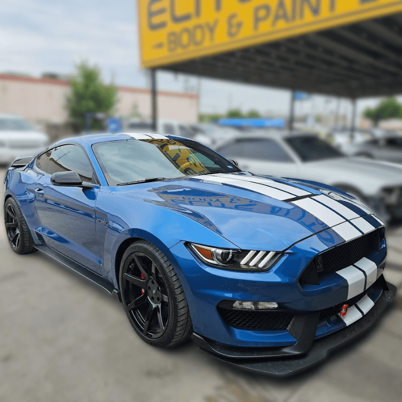 Blue Shelby Cobra with white stripes parked at Elite Auto Body Shop after repair service